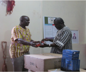 Liberia's Information Minister receives audio equipment from HC3's Teah Doegmah. 